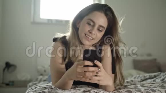 年轻的黑发和她的智能手机视频的预览图