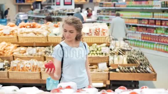 一个30多岁的购物狂在市场上研究蔬菜视频的预览图