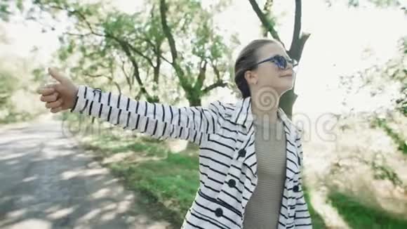 一个年轻时髦的女孩正在路上赶汽车一个穿着黑白外套戴着墨镜的快乐女孩走着视频的预览图