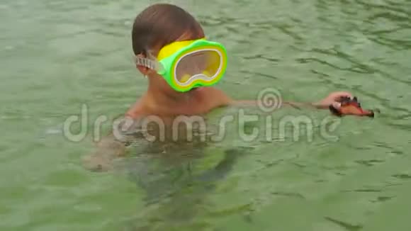 小男孩在海里玩耍浮潜和捕捉红星鱼的慢镜头视频的预览图
