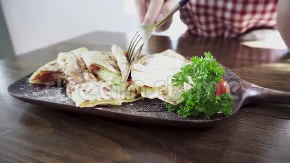 女人切肉吃墨西哥素食玉米饼视频的预览图