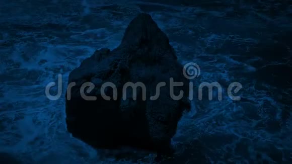 夜里海浪拍打着海中的岩石视频的预览图