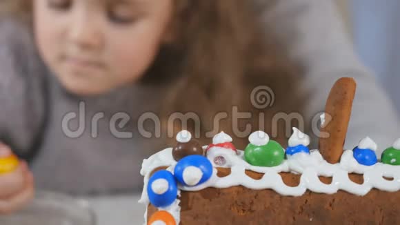 用五颜六色的糖果装饰姜饼屋一种白色的甜奶油视频的预览图