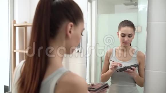 化妆女人用眼影看镜子视频的预览图