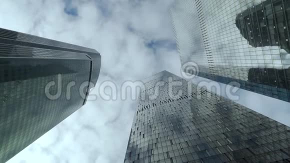 在多云的天空背景下看到现代摩天大楼的底部视频的预览图