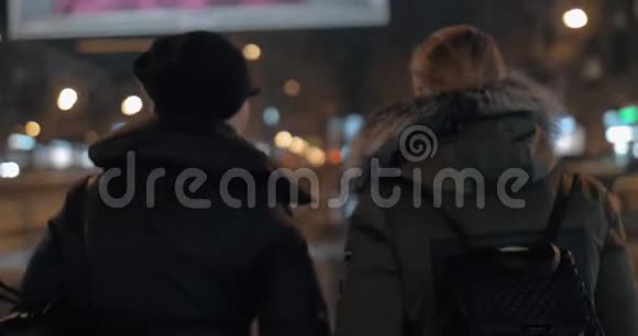 两个女人在冬天晚上散步时交谈视频的预览图