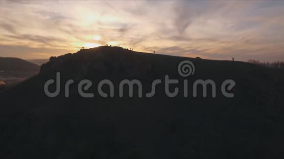 航拍人站在山顶欣赏日落视频的预览图
