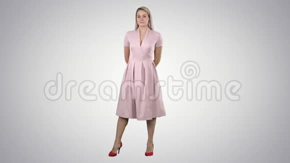 快乐美丽的女人穿着粉红色的裙子在渐变的背景下摆姿势视频的预览图