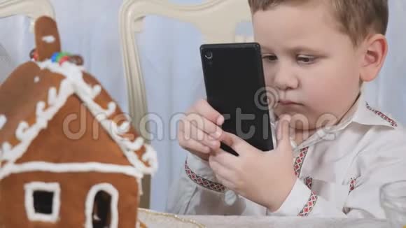 小男孩在智能手机上拍姜饼屋视频的预览图