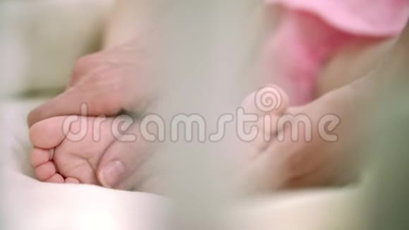 母亲用手抚摸婴儿的脚家庭的温柔产妇护理视频的预览图