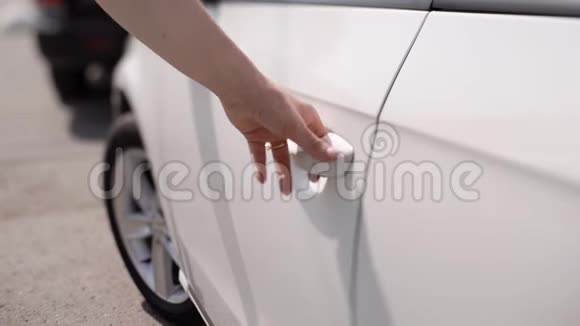 一个商业女人打开一辆白色汽车的门坐在里面视频的预览图
