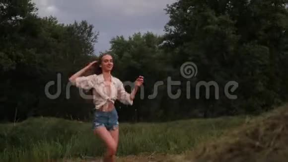 年轻的女人跑跳到干草堆她玩得很开心视频的预览图