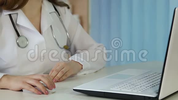 女医生在笔记本电脑上浏览网页打字在线咨询病人视频的预览图