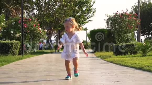 可爱的女孩走在公园的小路上视频的预览图