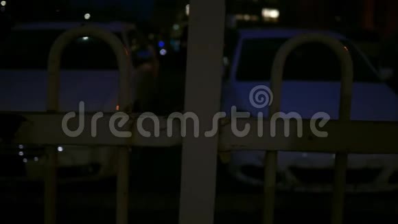 在大都市区的一个有栅栏的停车场晚上可以看到视频的预览图