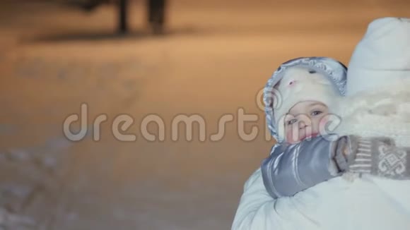 可爱的小女孩在冬天公园拥抱妈妈视频的预览图