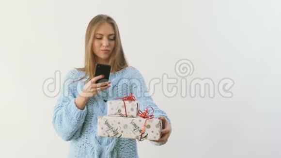 年轻女孩在白色背景下制作节日礼物的照片视频的预览图