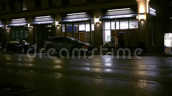 人们在下雨的晚上在城里的一般商店里散步视频的预览图