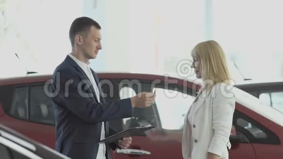 女商人签了一份文件推销员把车钥匙给了快乐的顾客视频的预览图