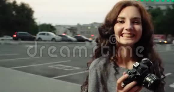 带着复古相机的女孩在街上微笑视频的预览图