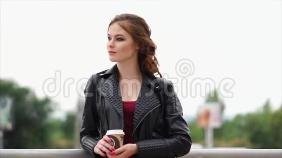 一个年轻的女人一头红发手里拿着一杯外卖的咖啡凝视着远方视频的预览图