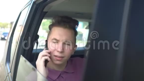 微笑的少年坐在汽车后座打电话视频的预览图