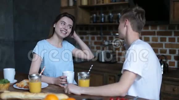 可爱的一对夫妇在现代厨房吃早餐视频的预览图