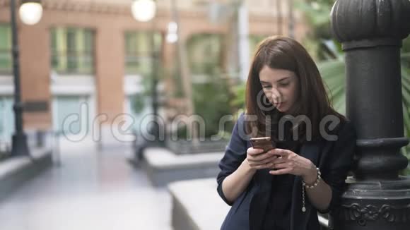 马德里阿托卡火车站有智能手机的冷静年轻女子视频的预览图