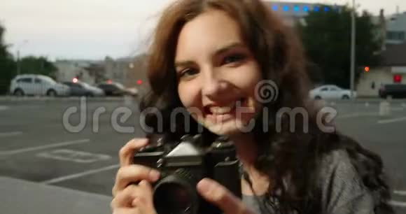 带着老式相机的嬉皮士女孩在街上微笑视频的预览图
