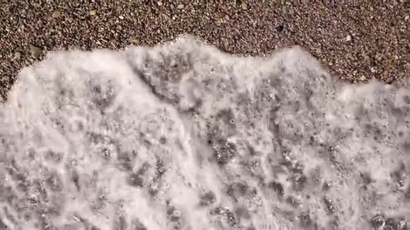 海浪在沙滩上逼近慢动作顶部视图视频的预览图