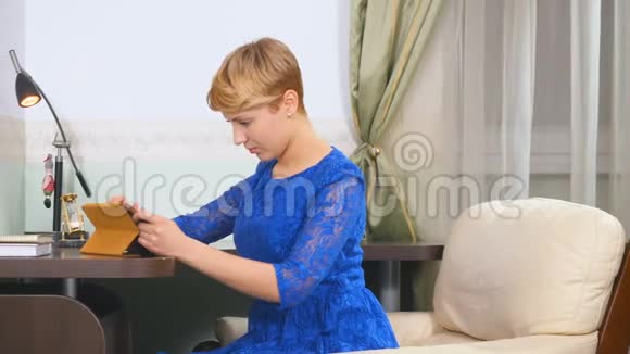 穿蓝色衣服的女人用平板电脑视频的预览图