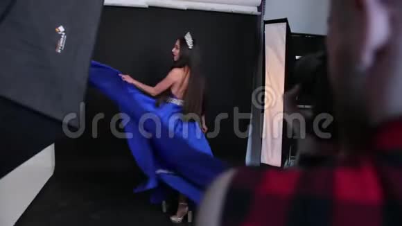 摄影棚里拍摄的照片一个穿着蓝色裙子深领线的黑发女孩视频的预览图
