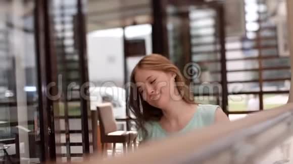 一个穿着蓝色裙子的女孩从咖啡馆的桌子上站起来女孩在笑视频的预览图