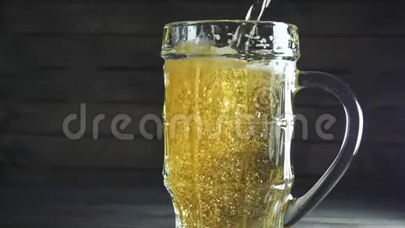 把啤酒倒入啤酒杯的慢镜头深色木制背景视频的预览图