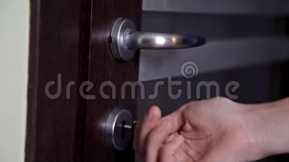 女孩打开并关上了公寓的门使用钥匙并锁门的人视频的预览图