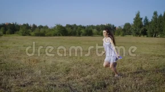 在城市景观的草地上奔跑时穿着打扮的女孩的侧视视频的预览图