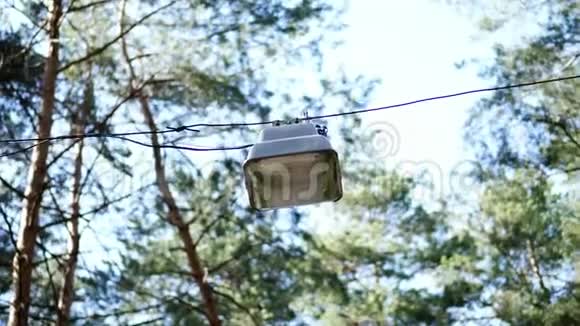 特写在天空和树梢的背景下挂着一盏大路灯松林视频的预览图
