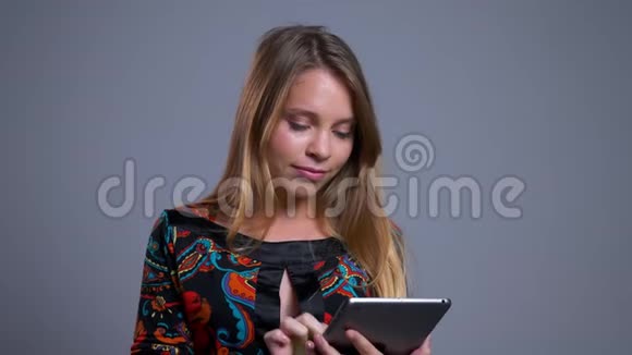 特写年轻开朗的白种人女士在平板电脑上浏览并向相机展示绿色屏幕微笑视频的预览图