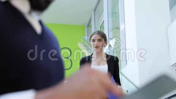 商务办公室男人和女人带着文件夹在楼梯上说话视频的预览图