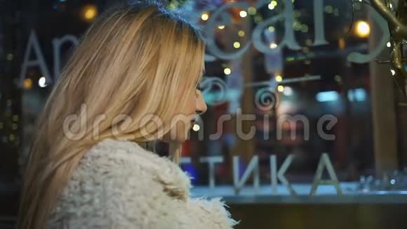 漂亮的变性女人站在一扇装饰着圣诞装饰的橱窗前看着它碰着玻璃视频的预览图