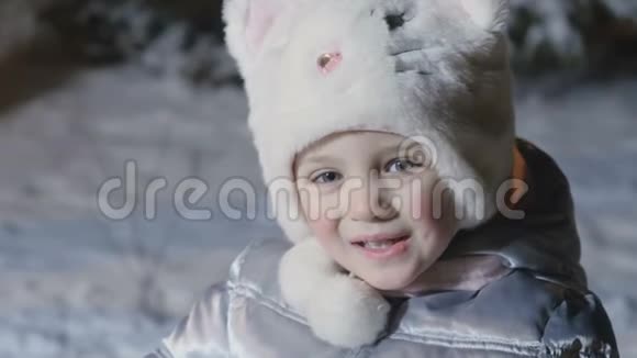 雪地背景下戴帽子的可爱小女孩的画像视频的预览图
