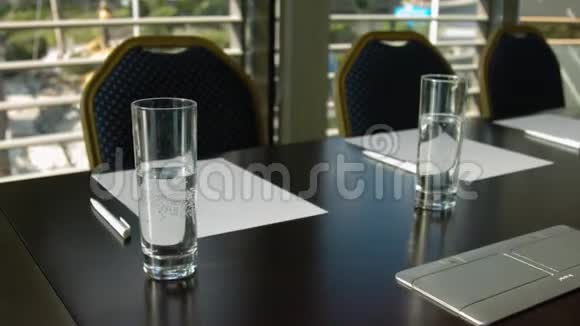 空的会议厅内部有桌子未经处理的椅子纸张和带水的玻璃杯视频的预览图