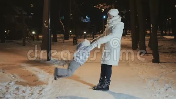 母亲正在冬季公园晚上围着女儿转视频的预览图