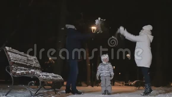 男人和女人慢慢地向公园里的小女儿扔雪视频的预览图