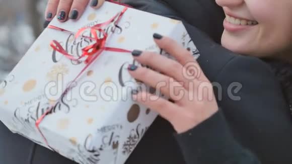 女孩拿着节日礼物拥抱她的男朋友视频的预览图