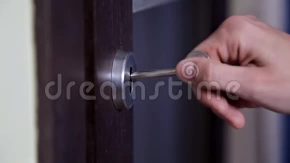 女孩打开并关上了公寓的门使用钥匙并锁门的人视频的预览图