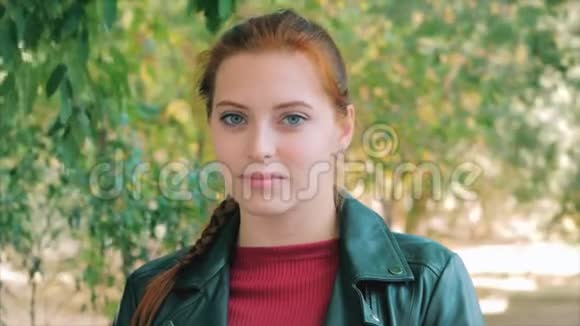一张迷人的微笑的年轻女子特写脸的肖像一个心情愉快积极的红色长发的快乐女人视频的预览图