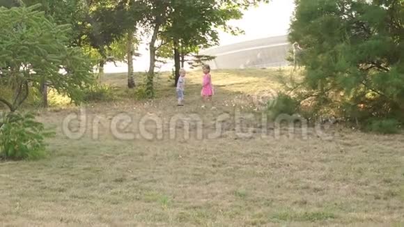 日落时三个孩子在公园里跑步视频的预览图