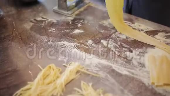 厨师的手使用意大利面切割机新鲜的意大利面从意大利面机里出来很慢视频的预览图