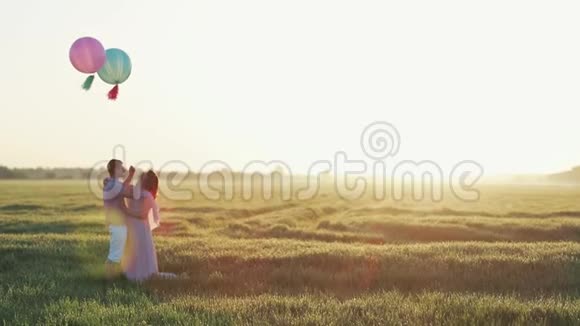 一对在田里抱着氦气球亲吻的情侣视频的预览图